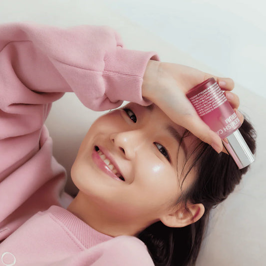 ISOI Brightening Serum 35ml – lächelnde Frau hält die Pipettenflasche vor rosa Hintergrund