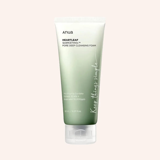 Anua Heartleaf Quercetinol Pore Deep Cleansing Foam 150ml – weiße Tube mit grüner Kappe und grünem Etikettfeld vor frischen grünen Blättern