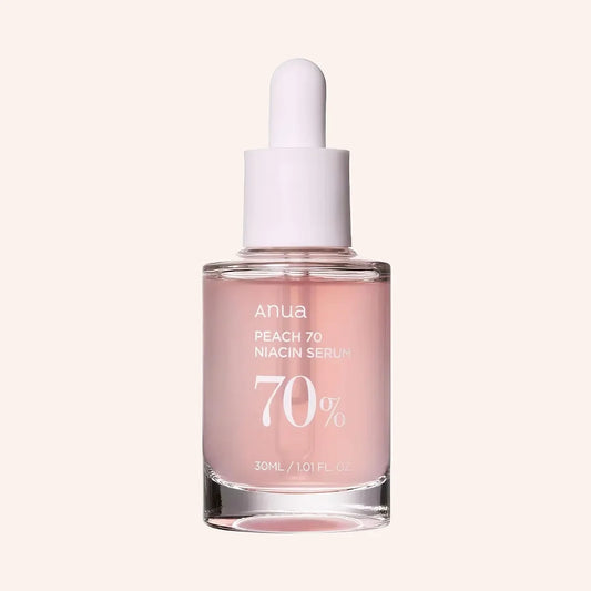 Anua Peach 70% Niacinamide Serum 30ml – klare Glasflasche mit zartrosa Pipette und rundem Etikett, schräg fotografiert vor dunklem Hintergrund