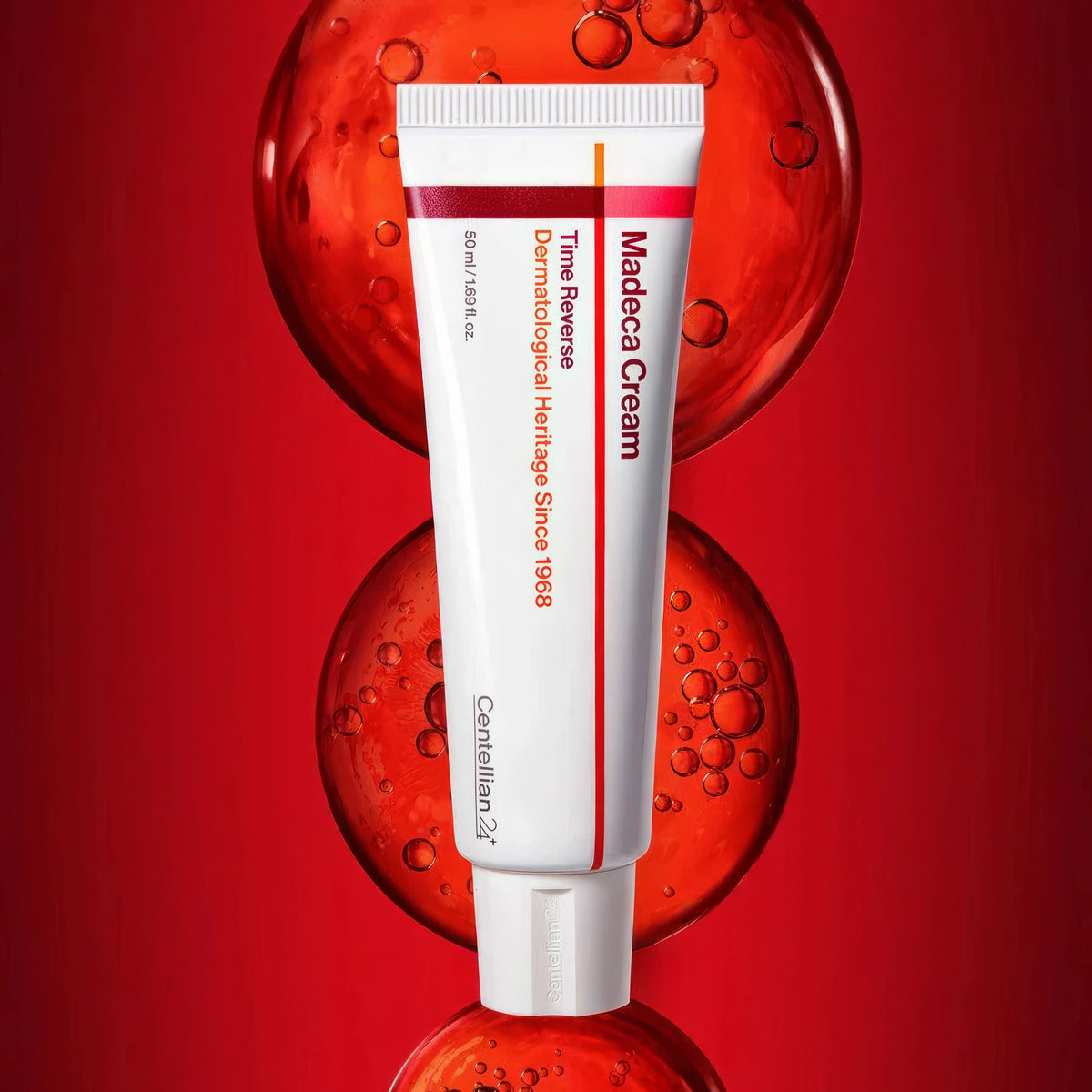 Centellian24 Madeca Cream Time Reverse 50ml – weiße Tube mit rotem Akzent unten, vor unscharfen roten Kugeln