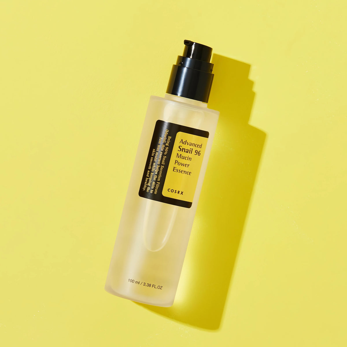 COSRX Advanced Snail 96 Mucin Power Essence 100ml – transparente Flasche mit Pumpspender vor leuchtend gelbem Grund