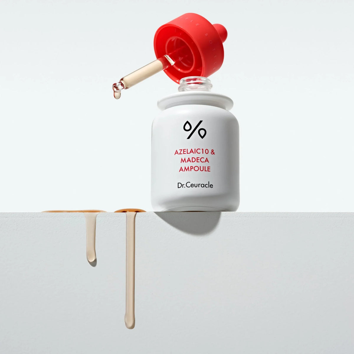 Dr. Ceuracle Azelaic 10 & Madeca Ampoule 30ml – weißer Behälter mit roter Kappe und klarer Pipette, Tropfenzeichnung