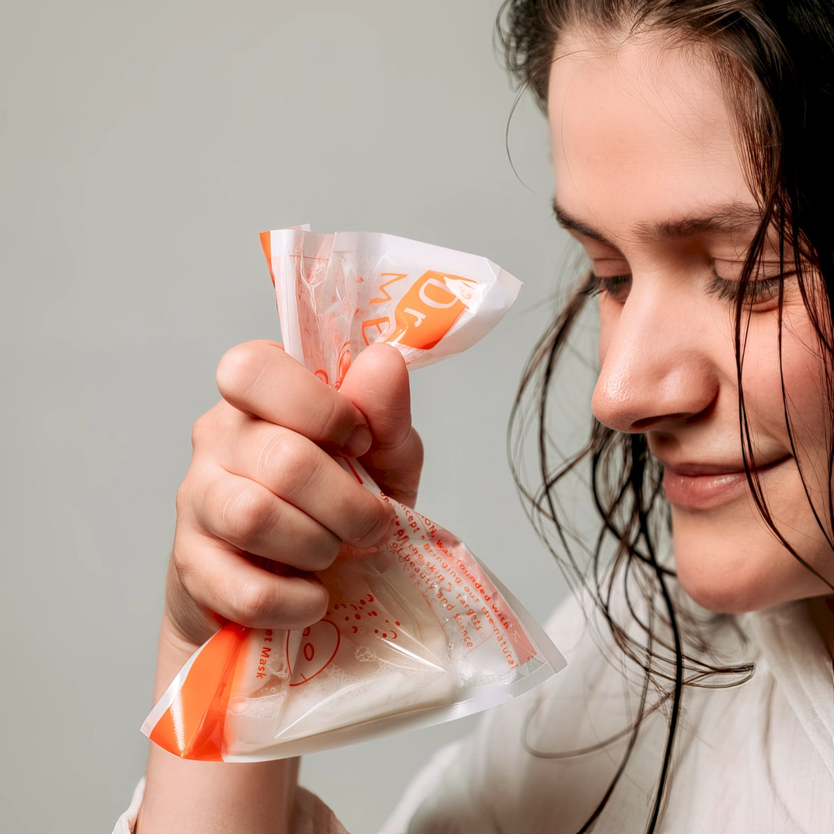Dr. Medion Spaoxy Mask – lächelnde Frau mit der Maskenverpackung in der Hand