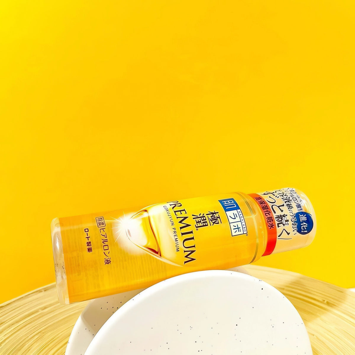 Hada Labo Gokujyun Premium Hydrating Lotion 170ml – Flasche auf weißem Teller, gelber Grund