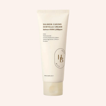 Heveblue Salmon Caring Centella Cream 100ml – weiße Tube mit braunem Etikett und Fisch-Illustration auf Schwarz