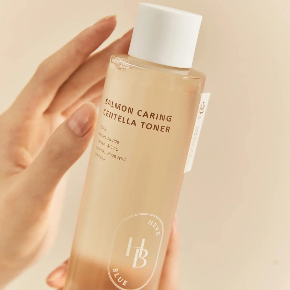 Heveblue Salmon Caring Centella Toner 200ml – transparente Flasche mit weißem Deckel in der Hand