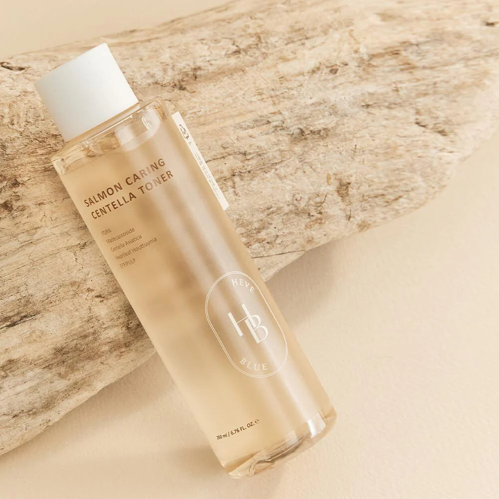 Heveblue Salmon Caring Centella Toner 200ml – Flasche mit weißem Etikett und fetter Schrift vor grünen Blättern