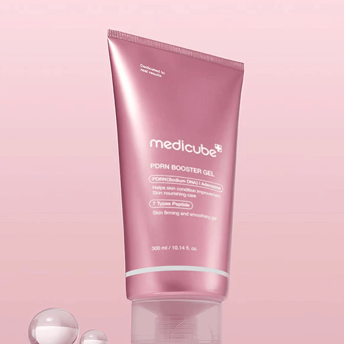 Medicube PDRN Booster Gel 300ml – leuchtend rosa Tube mit weißer Kappe, aufrecht stehend auf glatter rosa Oberfläche