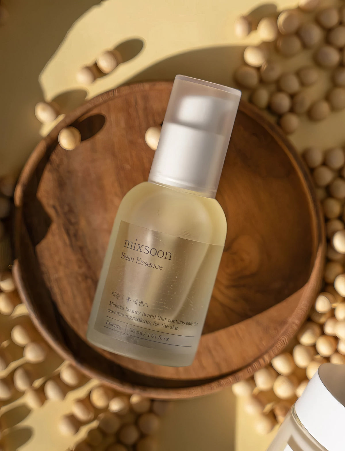 Mixsoon Bean Essence 30ml – Pipettenflasche auf Holz vor grün-goldenem Hintergrund