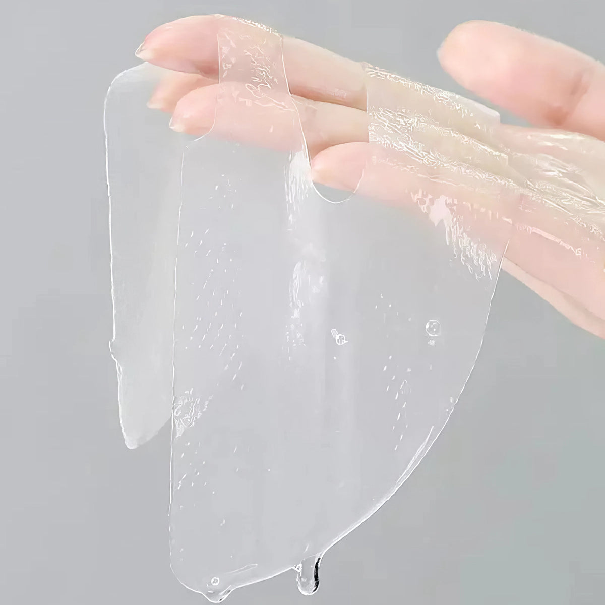 Mixsoon Bifida Mask Pack 25g – Hand hält entfaltete, transparente und dehnbare Gelmaske in Nahaufnahme