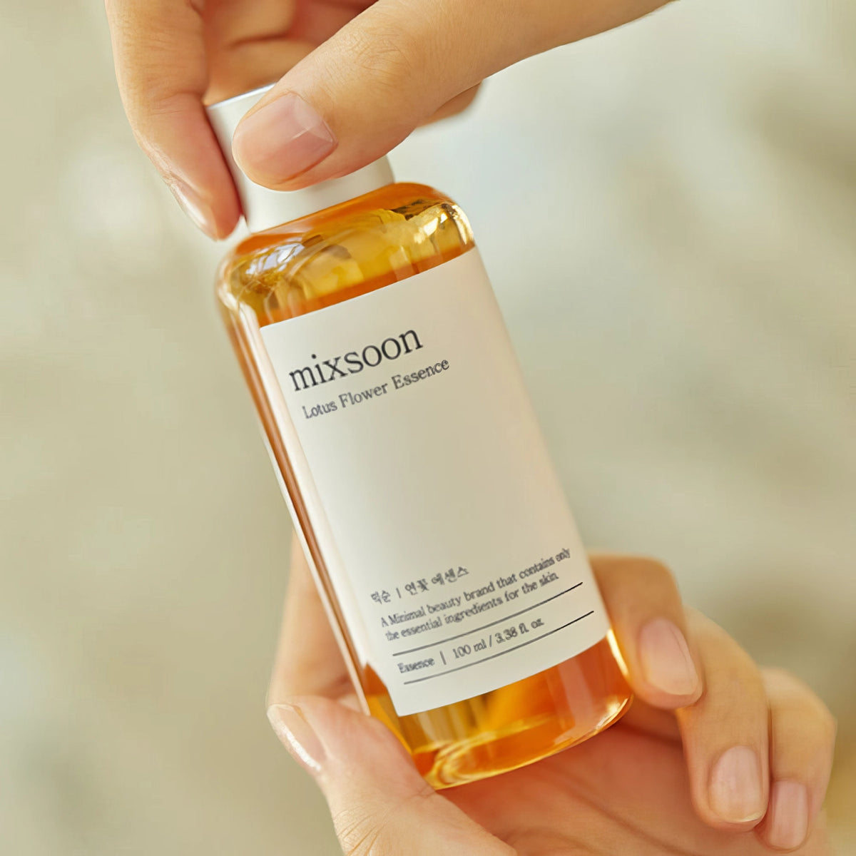 Mixsoon Lotus Flower Essence 100ml – gelbliche Flasche von einer Hand gehalten