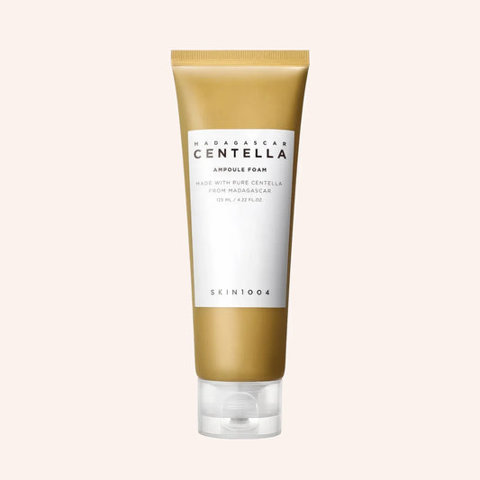 SKIN1004 Madagascar Centella Ampoule Foam 125ml – beige Tube mit Farbverlauf vor dunklem Hintergrund